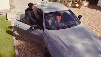 Silver BMW with man getting into it taken from above