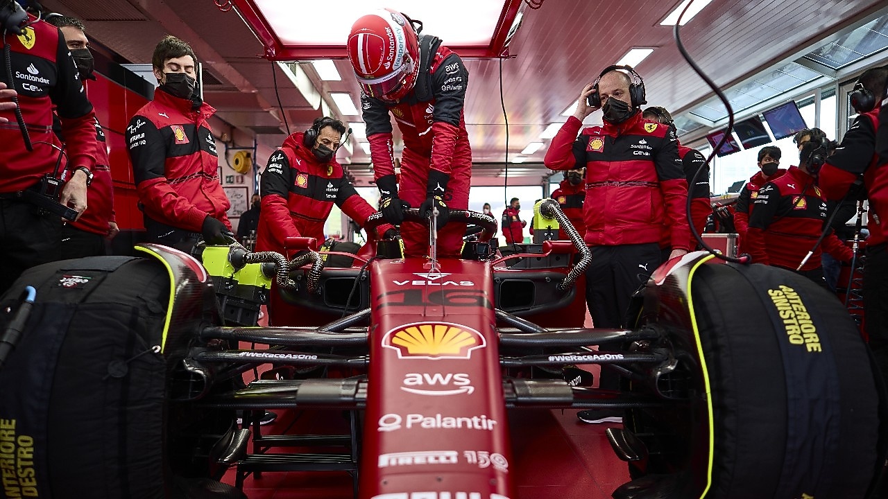 A close up of Ferrari car in the garage with Charles getting out of it