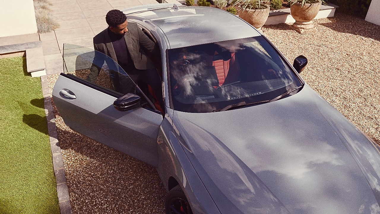 Silver BMW with man getting into it taken from above